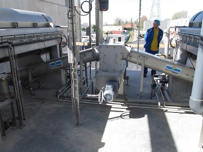 View of 2 sludge conveyors under decanter centrifuges